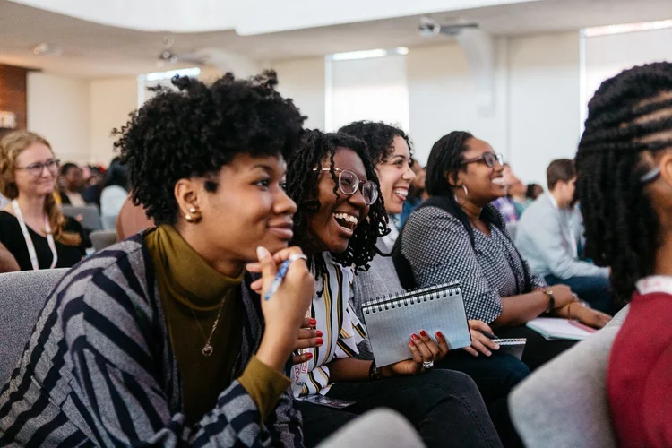 Young people sitting in chapel laughing.